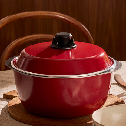 Red enameled cast iron Dutch oven on a wooden surface with a blurred background
